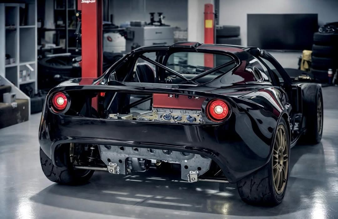 Black Lotus Elise S2 K-swap rear view showing roll cage and mid-mounted Honda K-series engine