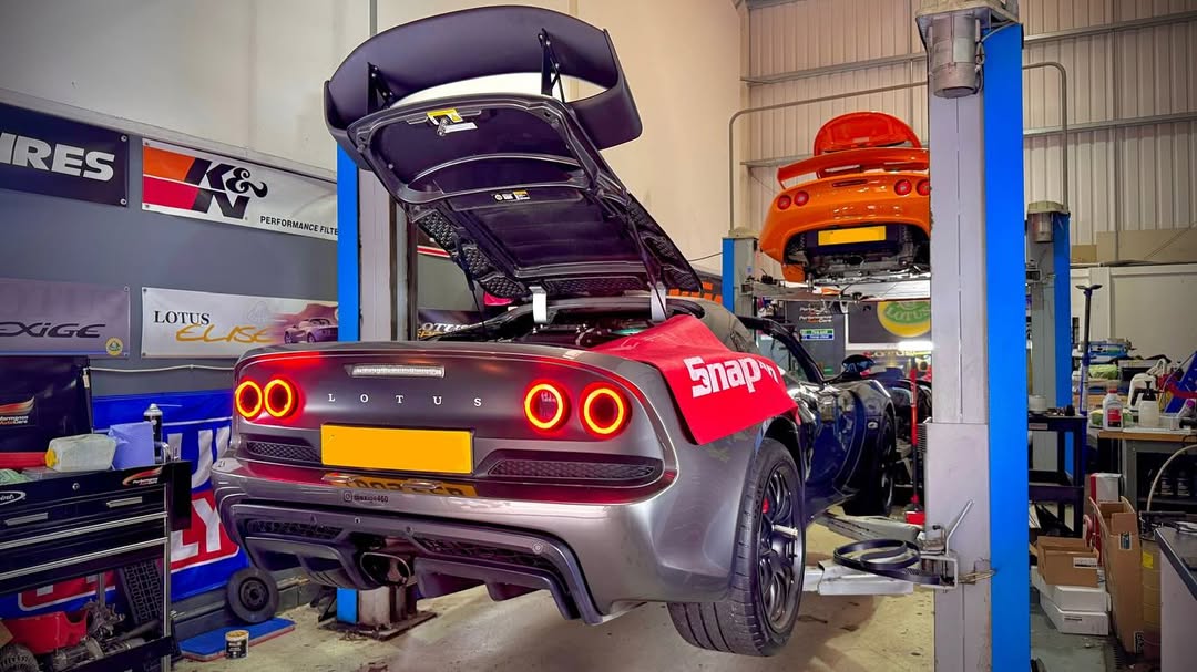 Grey Exige and orange Elise in Performance Autocare Workshop